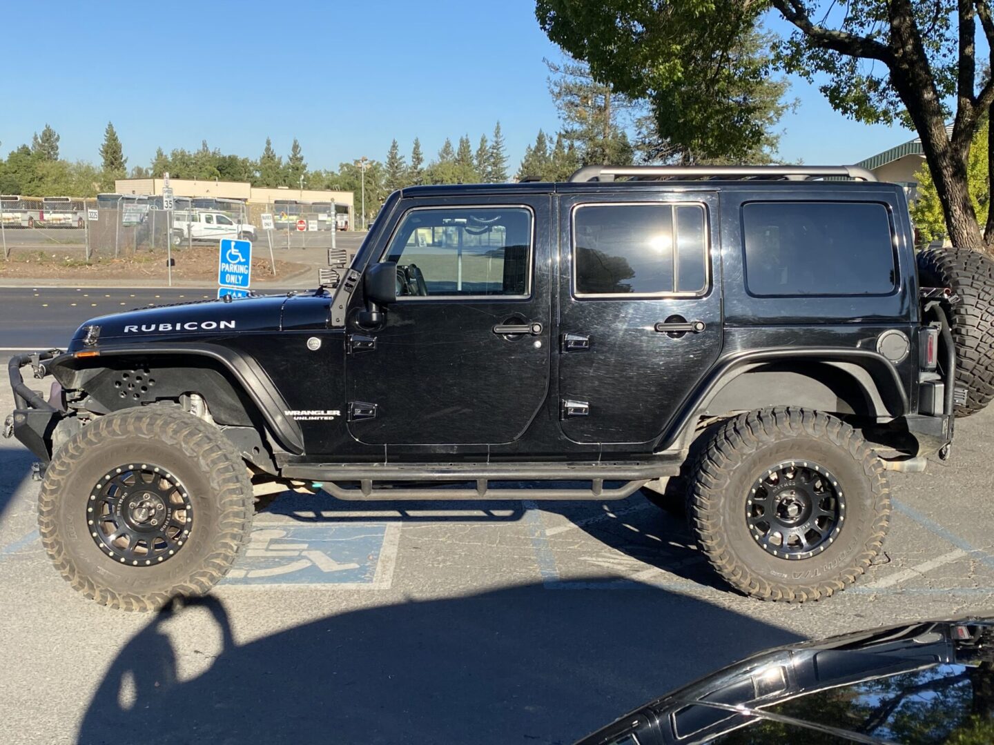 Black Jeep Rubicon after exterior detail — side profile in parking lot