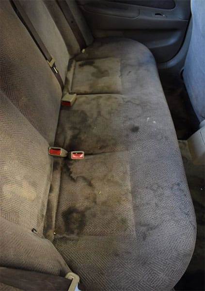 Dirty rear bench seat before interior cleaning