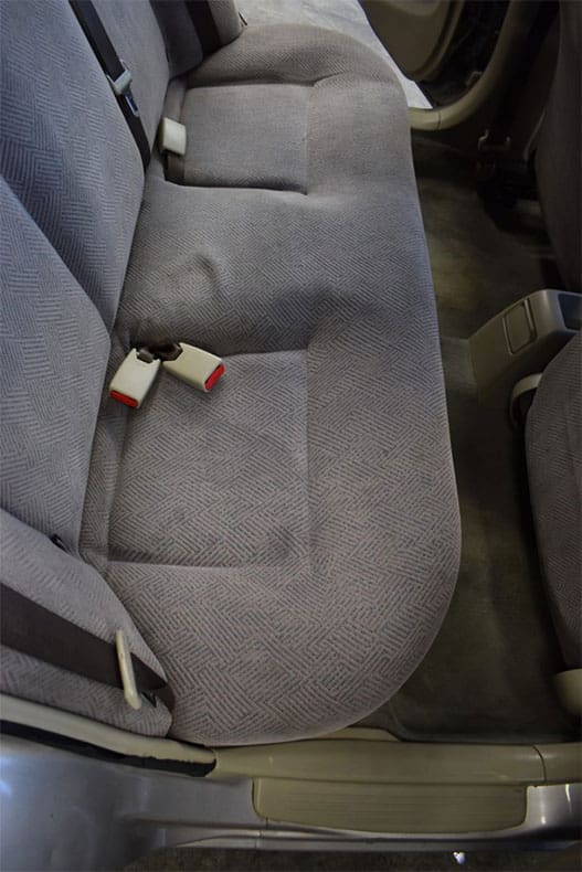 Clean rear seat after interior detail — gray upholstery restored