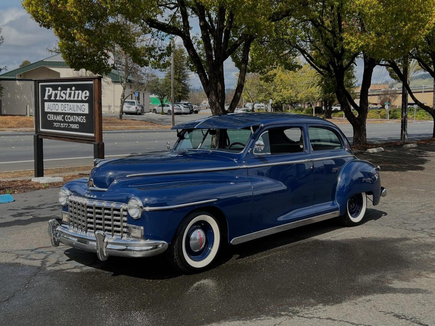 Blue vintage car parked near detailing shop