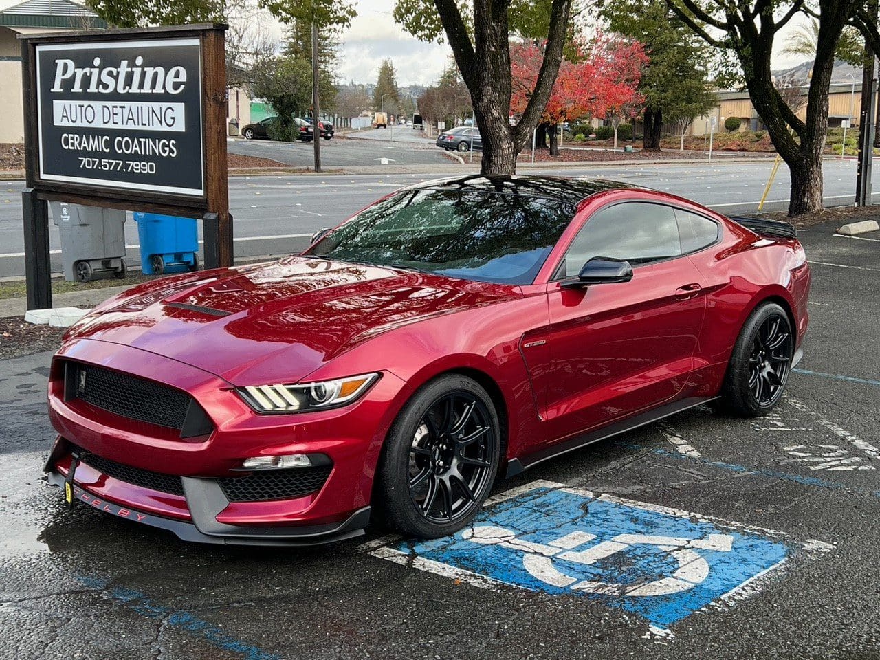 Red sports car parked in handicapped space
