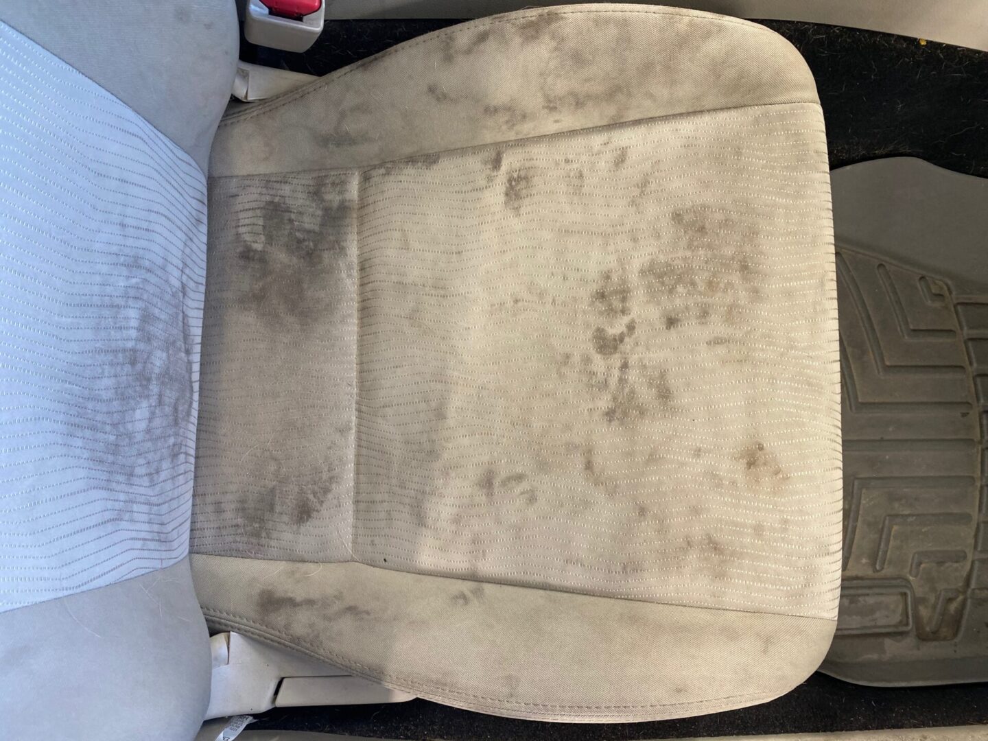 Stained beige car seat before interior detail service